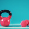 Pink kettlebell and dumbbell on a blue gradient background